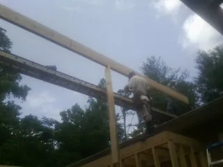 Carpenter setting a ridge beam over a new addition frame — Ice Dam Removal by Roofing Brothers in Tetonia