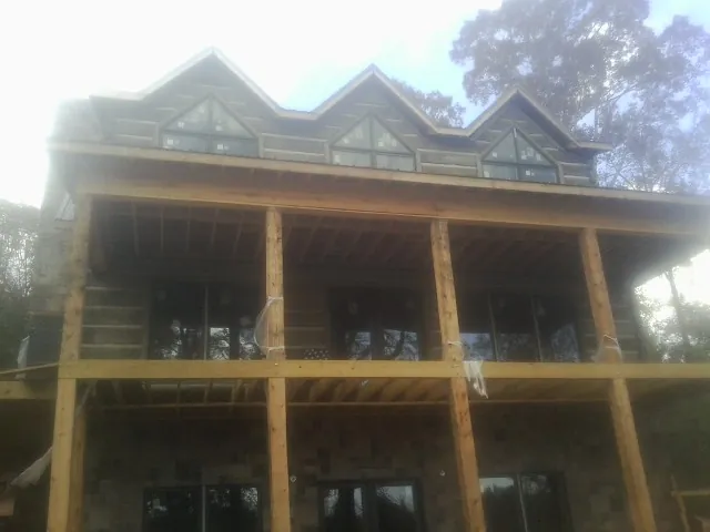 Dormers and porch framing on a large log home under construction — Roof Coating work by our crew in Tetonia