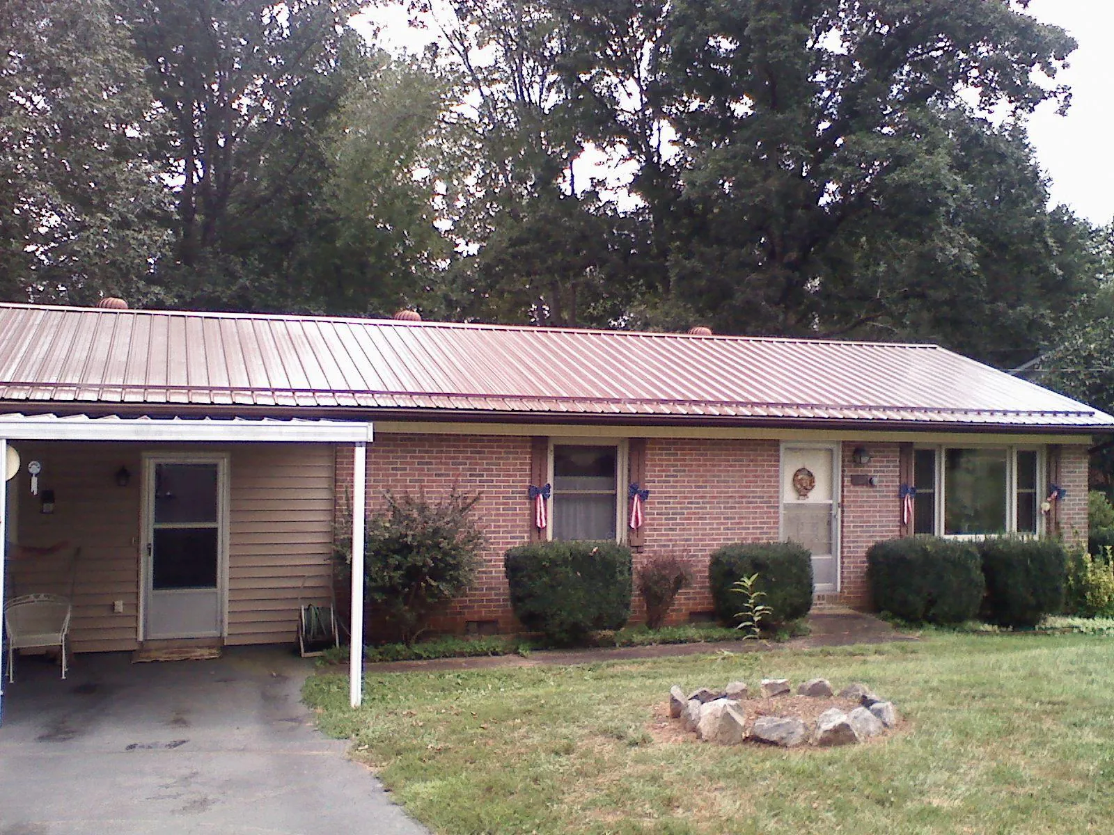 Bronze metal roof and carport on a brick ranch home — Roof Repair work by our crew in Tetonia